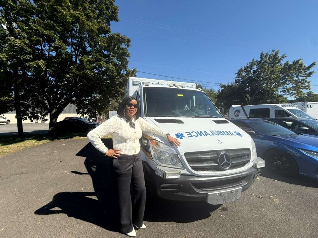 Founder standing in front of the donated ambulance