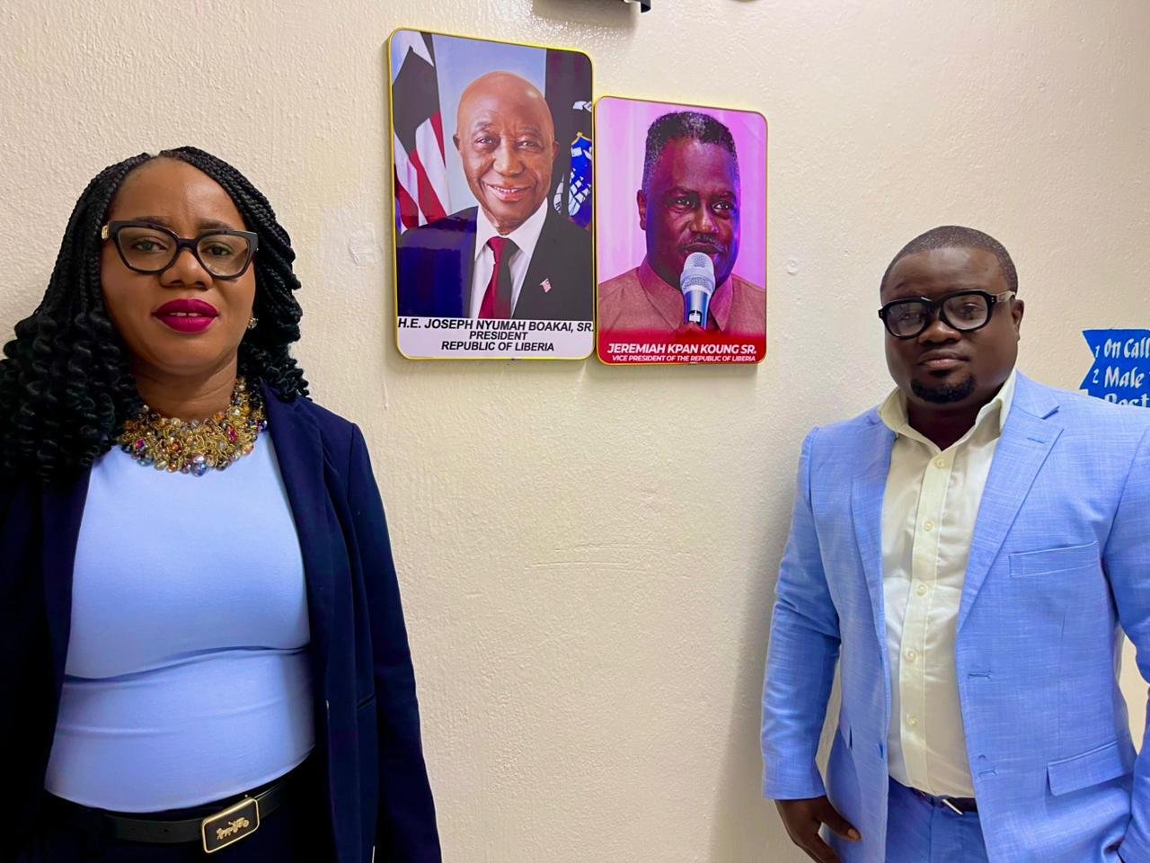 CAMF founders beside portraits of Liberia's president and vice president