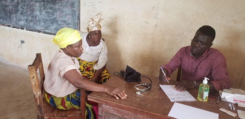 A patient consults with a provider at the July 2025 outreach in Fanti Town